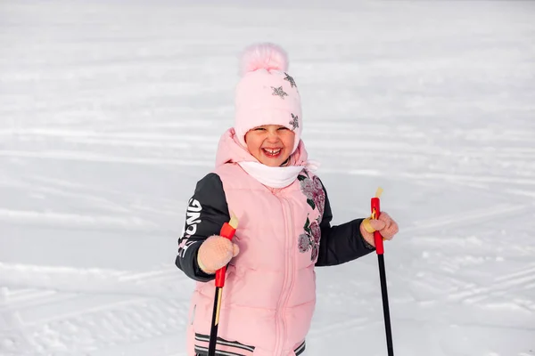 Zbliżenie małej dziewczynki. Portret szczęśliwego dziecka, które rano uczy się jeździć na nartach w śnieżnym lesie, zimowy krajobraz — Zdjęcie stockowe