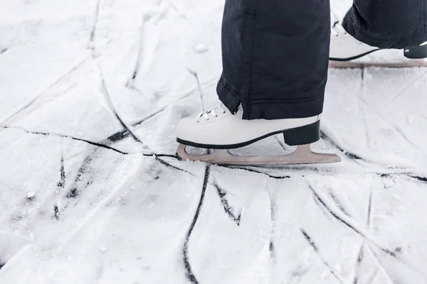 Foto de close-up de patins. Patinação artística branca patins usados em pessoas pés, desenhando no gelo de lâminas de patins — Fotografia de Stock