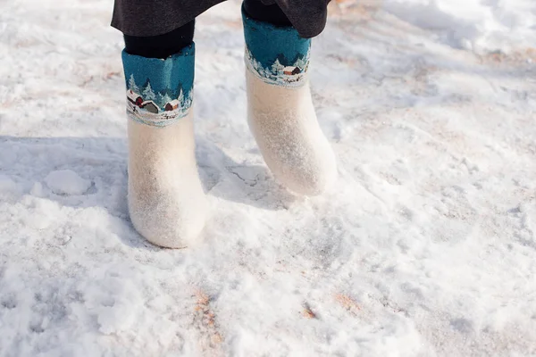Keçeli çizmelere yakın çekim. Kışın şiddetli kar fırtınasından sonra yağan, üzerinde org deseni olan beyaz keçeli çizmeli adam, saf karın üzerinde duruyor. — Stok fotoğraf