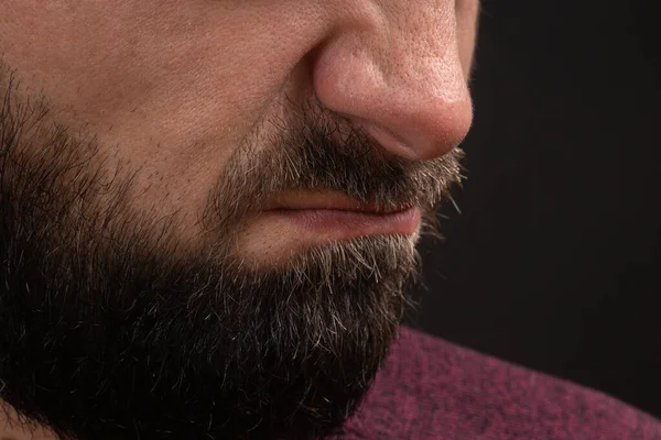 Wrinkled grimace of danger, closeup on face and lips of young unrecognizable man with black beard and mustache, concept of rage and anger – stockfoto