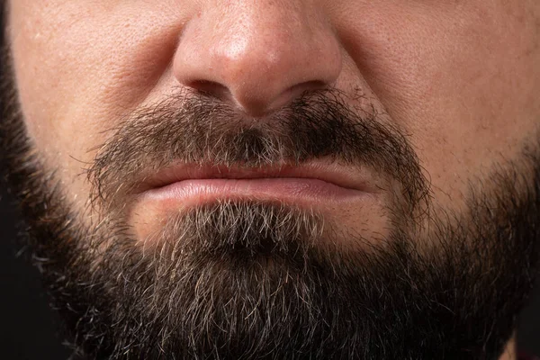 Emotion of disgust, hatred close-up on face and lips of young unrecognizable man with black beard and mustache, concept of rage and anger — Stock Photo, Image