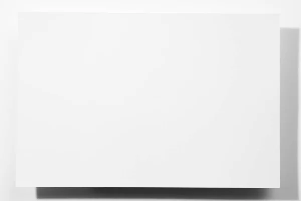 紙の大きな段ボール空白の白い色のシート-白い背景に影が落ちる長方形の形のバナー。カードモックアップ。スペースのコピー — ストック写真