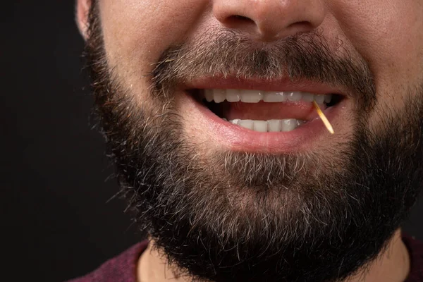Χαμογελαστό αρσενικό αξύριστο πρόσωπο κοντινό πλάνο με ανοιχτό στόμα και γλώσσα που παίζει με οδοντογλυφίδα, κακούς τρόπους και παραβίαση της εθιμοτυπίας — Φωτογραφία Αρχείου