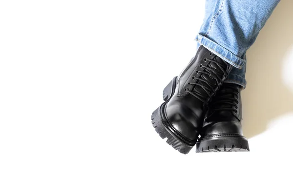 Leather female boots of black color with round toe, block heel and embossed hard sole worn on woman feet isolated on white background with shadows from legs. Copy space — Stock Photo, Image