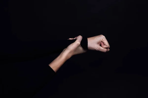 Mão caucasiana segurando o punho cerrado de abusar de alguém no fundo preto. Violência doméstica. Espaço de cópia Abuso físico e psicológico, agressão relativa, gaslighting — Fotografia de Stock