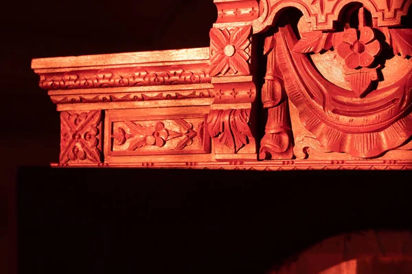 Erstaunliche handgeschnitzte Ornamente aus antiken Schränken aus Holz im Dunkeln, auf die etwas Licht fällt. Altem Stoff neues Leben einhauchen. Handrestaurierung alter Möbel — Stockfoto