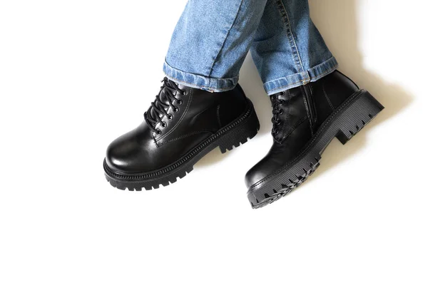 Black leather female autumn boots isolated with white background and shadows from legs with round toe, block heel and embossed hard sole worn on woman feet. Copy space — Stock Photo, Image