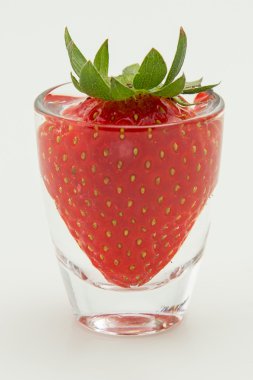 küçük bir bardak su içinde çilek düz görünüm