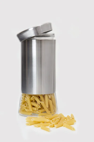 Silver pasta recipient with a pasta type pile in front — Stock Photo, Image