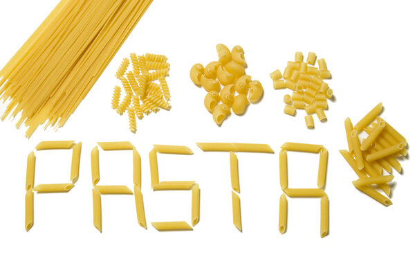 Pasta letters with various types of pasta in piles above, isolated
