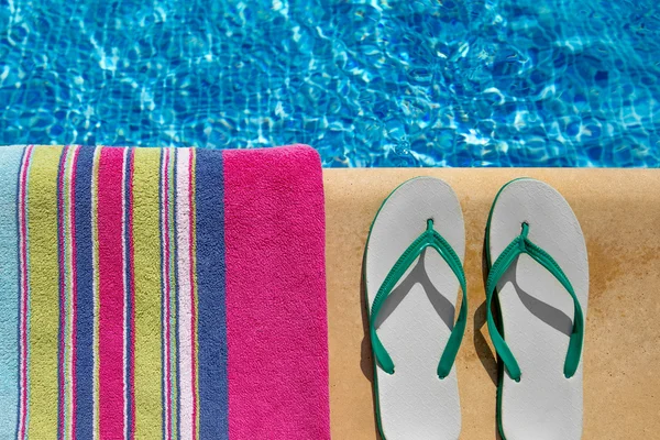 havlu ve flip flop'lar Yüzme Havuzu kenarında yarısı