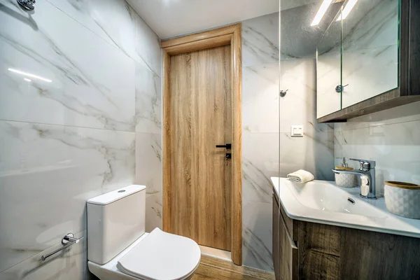 标准的现代化浴室室内设计 带有水池 墙壁上的镜子 木制看台 带有玻璃隔板的淋浴器 大理石般的瓷砖墙 — 图库照片