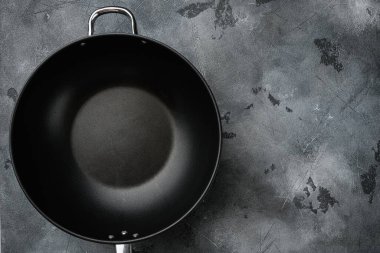 Wok pan boş seti metin ya da yiyecek için metin ya da yiyecek kopyalama alanı ile, üst görünüm düz, gri taş masa arkaplanı üzerinde