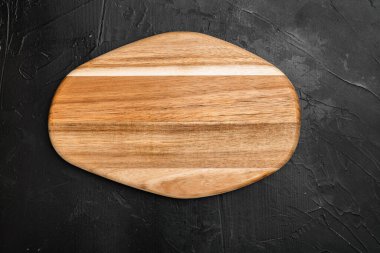 Çizilmiş kesme tahtası seti, siyah koyu taş masa arkaplanı, üst görünüm düz yatay, metin veya ürün için kopyalama alanı ile