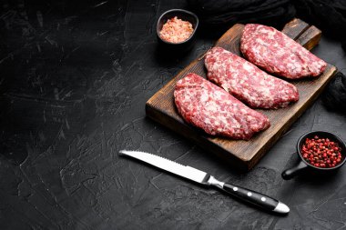 Saf kıyma köfteleri seti, siyah koyu taş masa arkaplanı üzerine, metin için kopyalama alanı ile