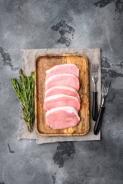 Domuz eti. Taze domuz bifteği seti, gri taş masa arkaplanı, üst görünüm düz, metin için kopyalama alanı ile