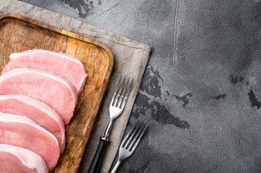 Çiğ organik et. Domuz bifteği, ızgara, fırın ya da kızartma seti için fileto, gri taş masa zemininde, üst görünüm düz, metin için kopyalama alanı