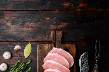 Dilimlenmiş çiğ domuz eti seti, eski koyu ahşap masa arkaplanı, üst görünümü düz, metin için kopyalama alanı ile