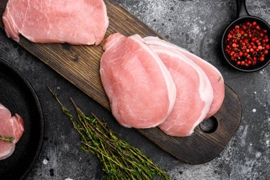 Domuz bifteği, çiğ et seti, siyah taş masa arkaplanı, üst manzara düz.