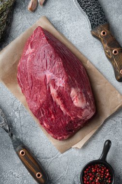 Gri arka planda eski kasap bıçağıyla kesilmiş sığır eti.