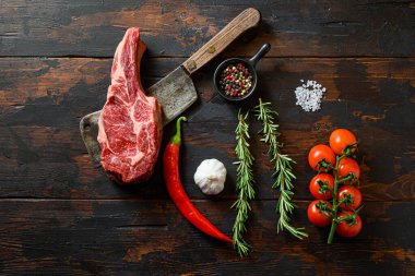 Et satırında çiğ Delmonico bifteği. Organik çiftlik mermer kaplama siyah angus bifteği. Koyu ahşap arka plan. Üst Manzara. Baharatlı, biberli, biberiyeli, tuzlu, sarımsaklı. Hiç kimse.