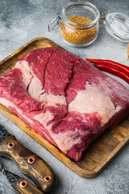 Çiğ mermer et seti, içinde sigara, barbekü, pastırma, tedavi için malzemeler var, gri taştan arka planda.