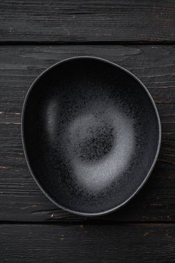 Boş siyah kase seti, metin veya yemek için kopyalama alanı, metin veya yiyecek için kopyalama alanı, üst görünüm düz, siyah ahşap masa arka planı