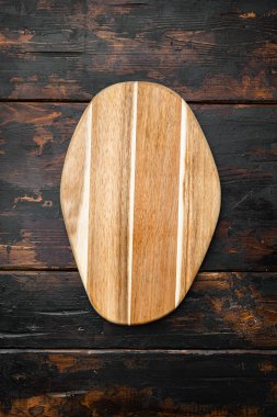 Eski koyu ahşap masa zemininde, çizilmiş kesme tahtası seti, üst görünüm düz yatay, metin veya ürün için kopyalama alanı ile