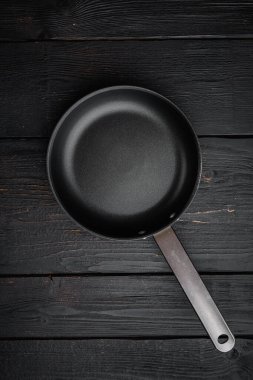 Metin ya da yiyecek kopyalama alanı olan metin ya da yiyecek için boş tava seti, üst görünüm düz tabaka, siyah ahşap masa arkaplanı