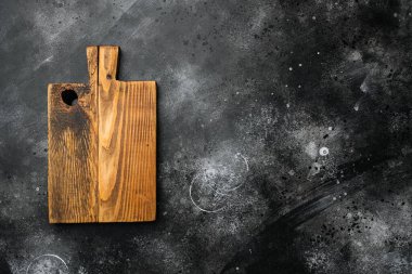 Eski ahşap kesme tahtası seti, üst görünüm düz yatay, metin veya yiyecek için kopyalama alanı, siyah koyu taş masa arkaplanı