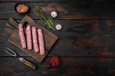 Taze ev yapımı sosisler seti, eski koyu ahşap masa arkaplanı üzerine, üst görünüm düz yatay, metin için kopyalama alanı ile