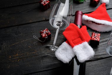 Şarap şişeli dekoratif Noel masası, siyah ahşap masa arkaplanı, metin için kopya alanı