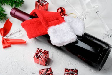 Şarap şişeleri Mutlu Noeller ve mutlu yıllar seti, beyaz taş masa arkasında