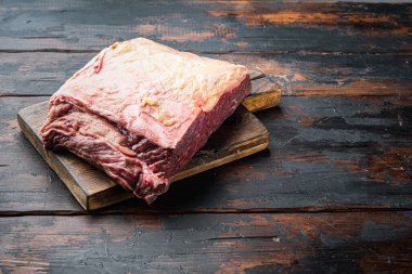 Strip biftek, mermer et, eski ahşap masada.