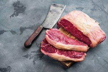 New York bifteği çiğ et, gri arka planda.