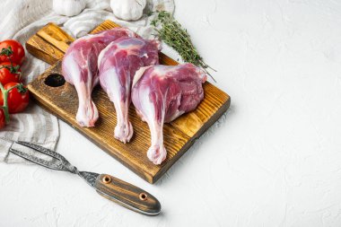 Serbest Çiftlik Ördek Bacakları seti, bitkiler ve malzemelerle ahşap kesim tahtasında, beyaz taş zemin üzerinde, metin için kopyalanacak yer ve alan