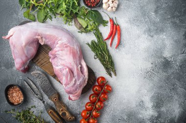 Taze sebzeli çiğ tavşan eti, otlar ve baharatlar seti, gri taş arka planda, üst görünüm düz, metin alanı için kopyalama alanı ile