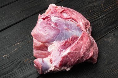 Domuz eti omuz seti, siyah ahşap masa arkasında.