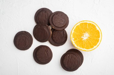 Turuncu çikolata kaplı bisküvi seti, beyaz taş masa arkaplanı, üst görünüm düz yatıyordu