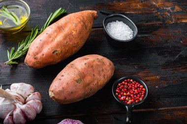 Eski ahşap masadaki bitkilerle dolu çiğ patates..