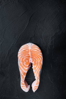 Siyah arkaplan üzerinde kırmızı balık somonu dilimi, metin için boşluk ile düz görünüm.