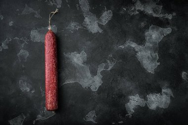 Lezzetli sosis seti, siyah taş zemin üzerinde, üst görünüm düz, metin için kopyalama alanı ile