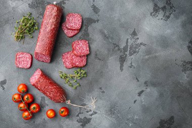 Salam, salam tütsülenmiş sosis, dilimlenmiş sosis, gri taş masa arkaplanı, üst görünüm düz, metin alanı için fotokopi alanı