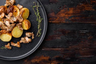 Kızarmış patates ve mantar seti, eski koyu ahşap masa arkaplanı, üst görünüm düz, metin için kopyalama alanı ile