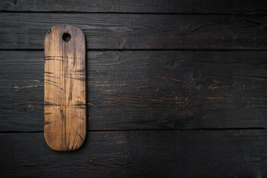 Boş sunucu tahtası seti, üst görünüm düz yatay, metin veya ürününüz için kopyalama alanı, siyah tahta masa arkaplanı üzerinde