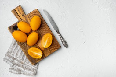 Sarı domates seti, beyaz taş masa arkaplanı, üst görünüm düz yatay, metin için kopyalama alanı