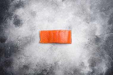 Somon balığı. Taze çiğ somon balığı filetosu seti, gri taş masa zemininde, üst görünüm düz, metin için kopyalama alanı var.