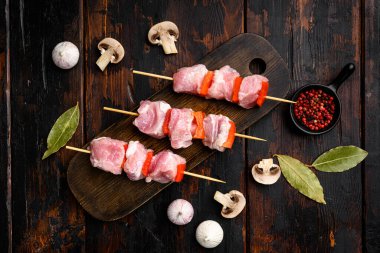 Çiğ kebap seti, üst görünüm düz, eski siyah ahşap masa arkaplanı üzerinde