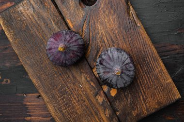 Sağlıklı tatlı incirleri seti, eski siyah ahşap masa arka planında, üst manzara düz yatıyordu.