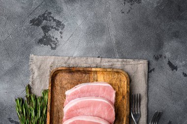 Domuz bifteği, çiğ et seti, gri taş masa arkaplanı, üst görünüm düz, metin için kopyalama alanı ile